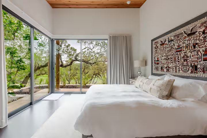 La Paz secondary bedroom with woven tapestry headboard and silver lamps