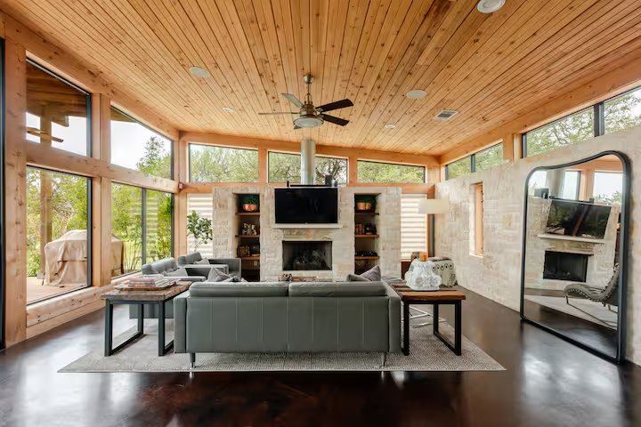 La Paz living area with stone fireplace, mounted TV, and built-in shelving
